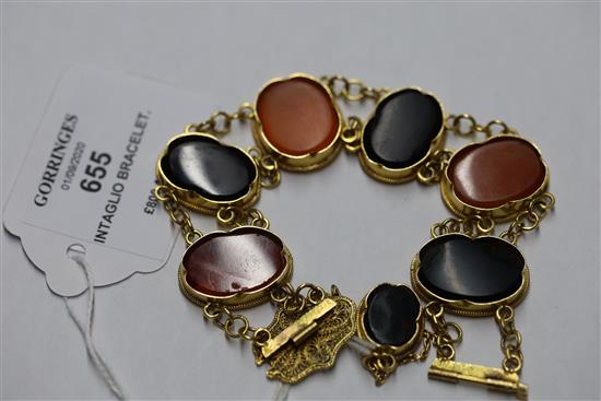 A late Victorian style gold and Intaglio hardstone bracelet, with filigree clasp and safety chain, gross 48.9 grams.